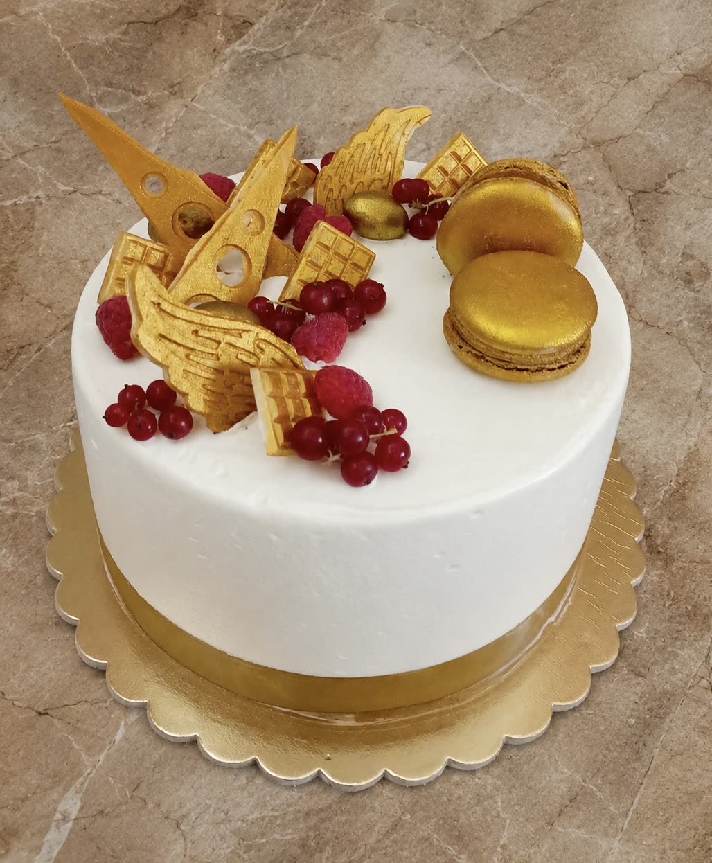 Fehér torta arany macaronokkal, ostyadíszekkel és ribizlivel