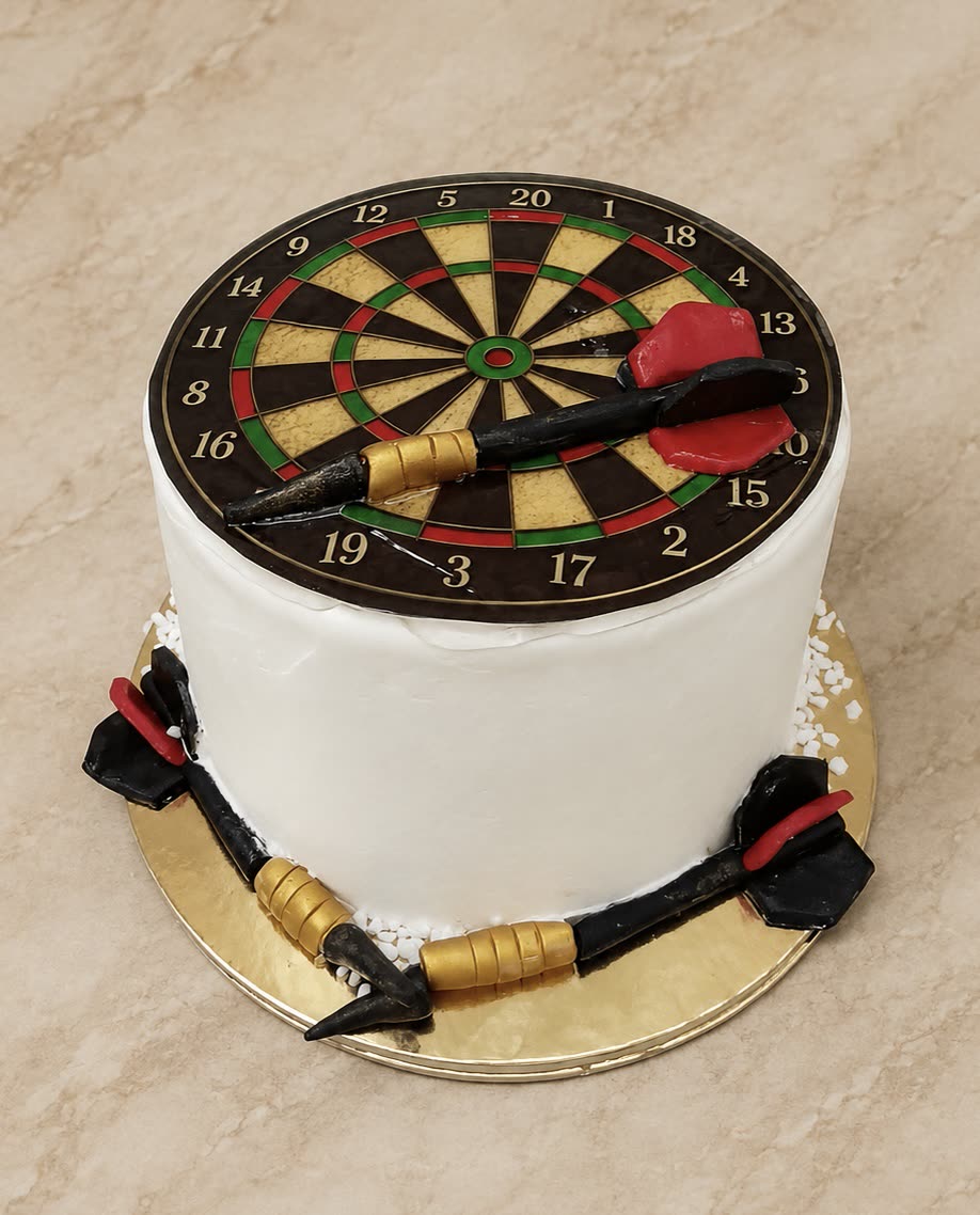 Fehér torta darts céltáblával és cukorból készült nyilakkal