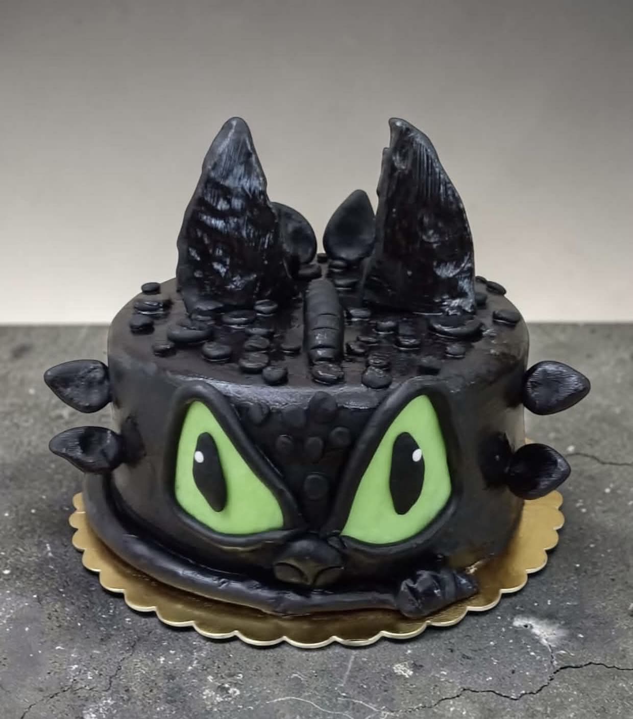 Fekete sárkány formájú torta zöld szemekkel és szárnyakkal