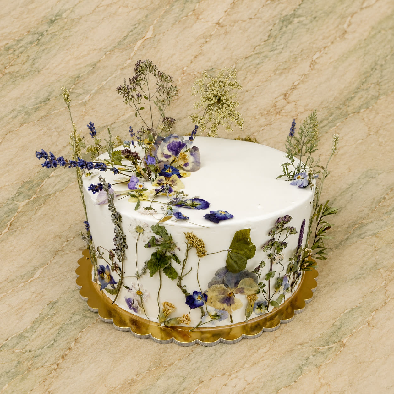 Fehér torta préselt mezei virágokkal és levelekkel