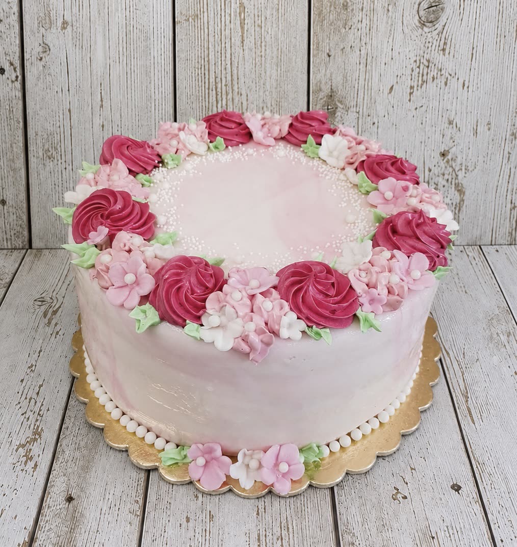 Rózsaszín torta habrózsa koszorúval és cukorvirágokkal