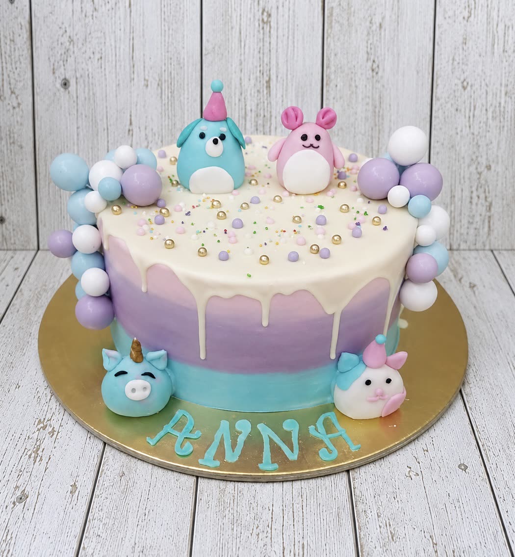 Pasztell lila-kék torta plüssfigurákkal és gömbfüzérrel