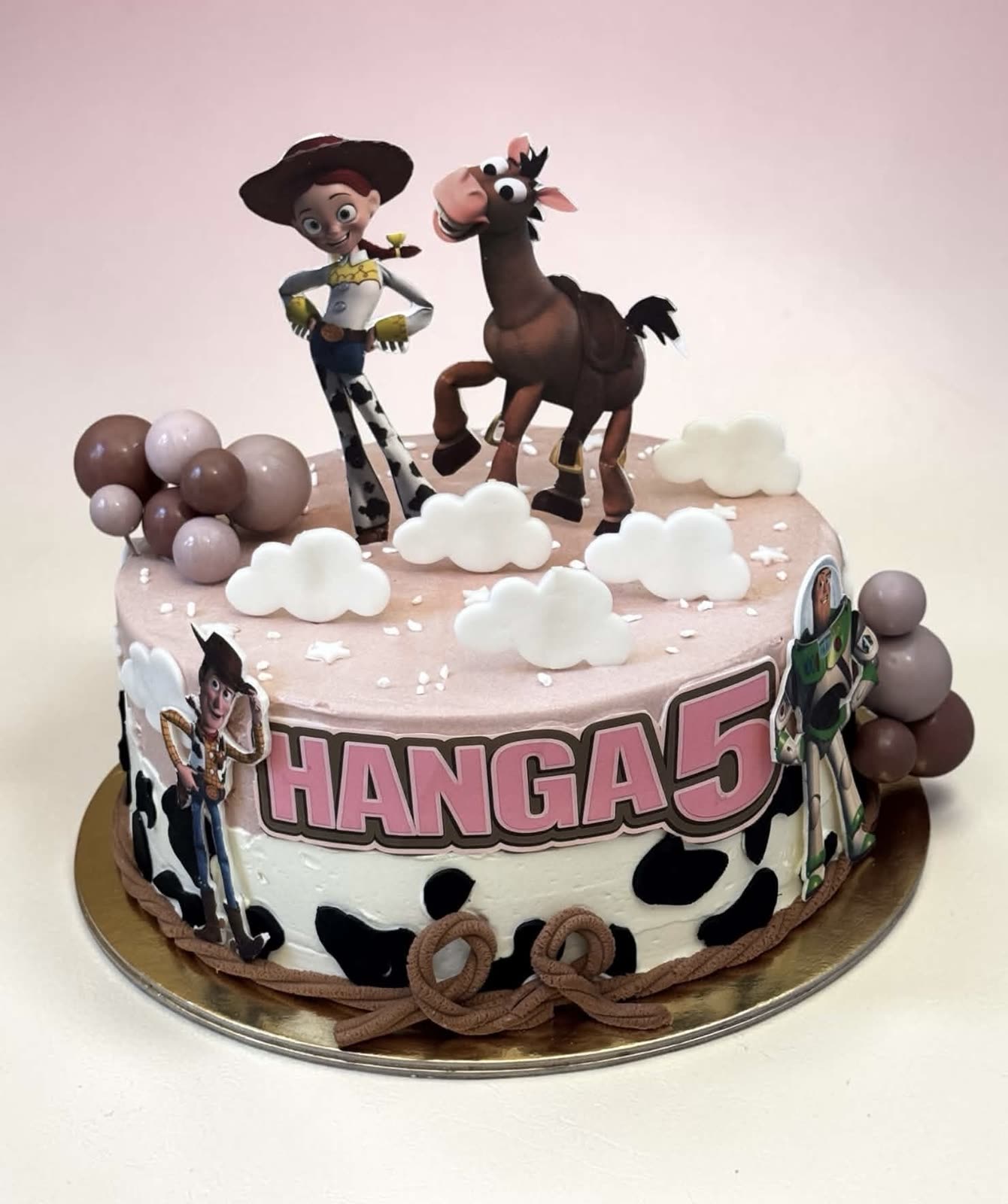 Rózsaszín-fehér Toy Story torta figurákkal és tehénmintával